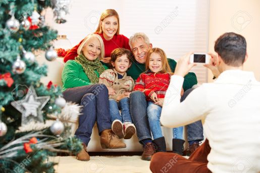 31536839-Father-taking-family-picture-at-christmas-with-his-smartphone-Stock-Photo